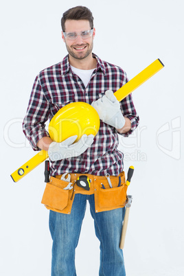 Handyman holding hard hat and spirit level