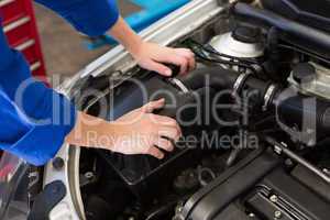 Mechanic examining under hood of car