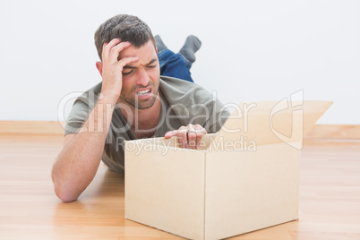 Troubled man open a moving box at home