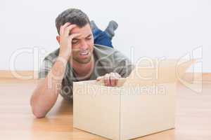 Troubled man open a moving box at home