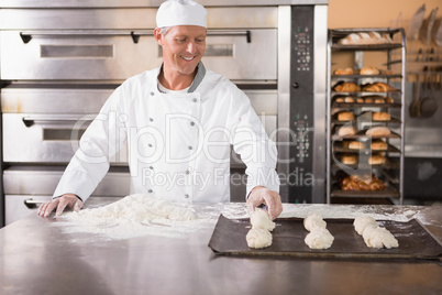 Baker putting dough on baking tray