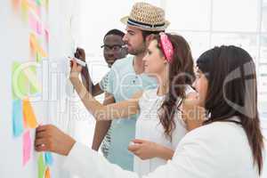 Business people writing ideas on sticky notes