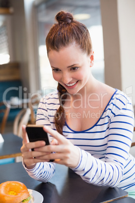 Young woman taking a photo of her lunch