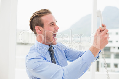 Angry businessman screaming on the phone