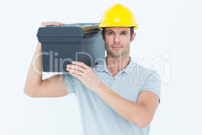 Confident worker carrying tool box on shoulder