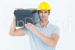 Confident worker carrying tool box on shoulder
