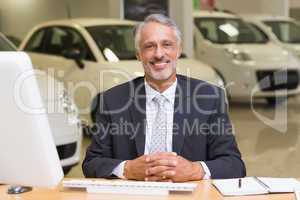 Smiling businessman sitting at his desk