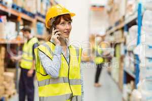 Warehouse manager talking on the phone looking around