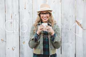 Smiling blonde holding take-away cup