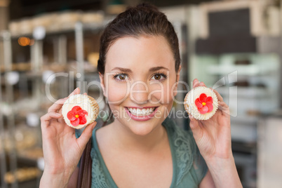 Pretty brunette showing a cupcake