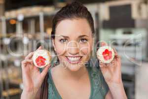 Pretty brunette showing a cupcake