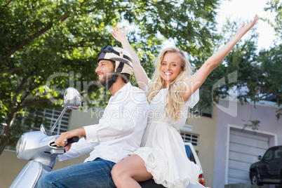 Attractive couple riding a scooter