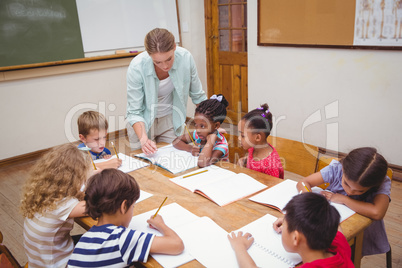 Teacher and pupils working at desk together