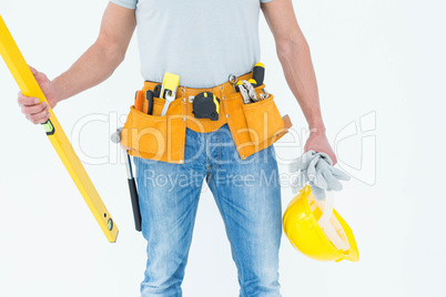 Repairman holding spirit level and hardhat