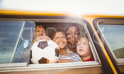 Cute pupils smiling at camera in the school bus