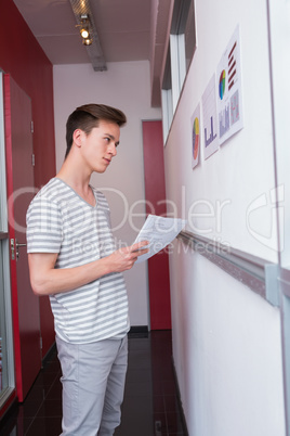 Student taking notes and looking graphics