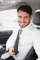 Businessman putting on his seat belt