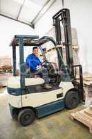 Driver operating forklift machine in warehouse