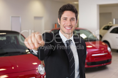 Salesman standing while offering car keys