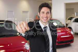 Salesman standing while offering car keys