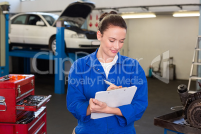 Mechanic writing on a clipboard