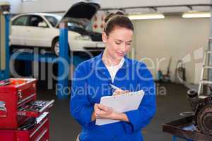 Mechanic writing on a clipboard