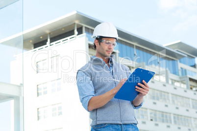 Architect writing on clipboard