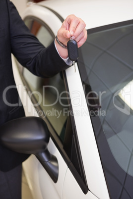 Close up of salesman showing car key