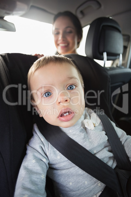 Mother checking her baby in the car seat
