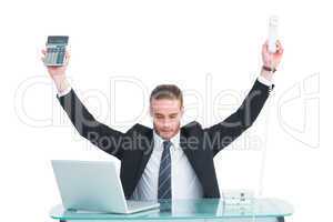 Businessman cheering holding calculator and telephone
