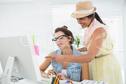 Colleagues using computer and pointing the screen