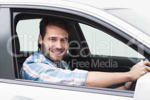 Young man driving and smiling