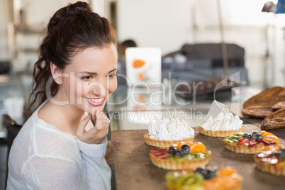 Pretty brunette looking at tarts