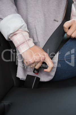 Woman putting on her seat belt