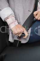 Woman putting on her seat belt