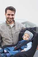 Father carrying baby in his car seat