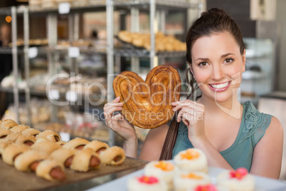 Pretty brunette holding heart shape pastry