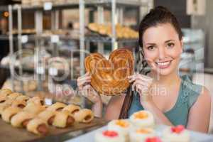 Pretty brunette holding heart shape pastry