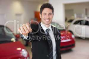 Salesman standing while offering car keys