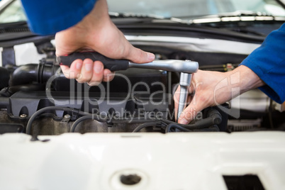 Close up of mechanic working on car