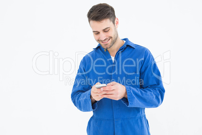 Male mechanic text messaging through mobile phone