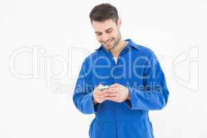 Male mechanic text messaging through mobile phone