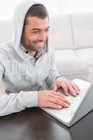 A smiling man using laptop at a table