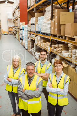 Smiling warehouse team with arms crossed