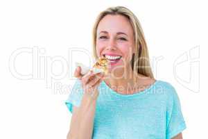 Smiling blonde eating slice of pizza
