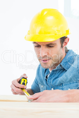 Carpenter measuring wood plank