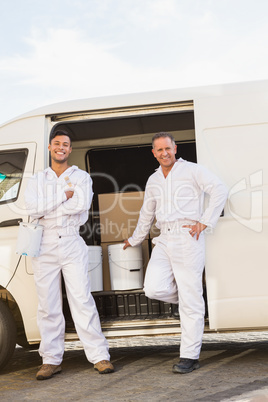 Painters smiling leaning against their van