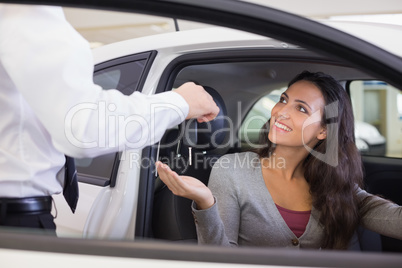 Salesman giving keys to a smiling woman