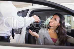 Salesman giving keys to a smiling woman