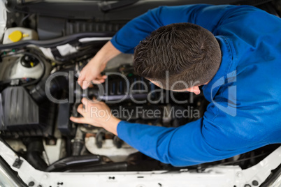 Mechanic examining under hood of car